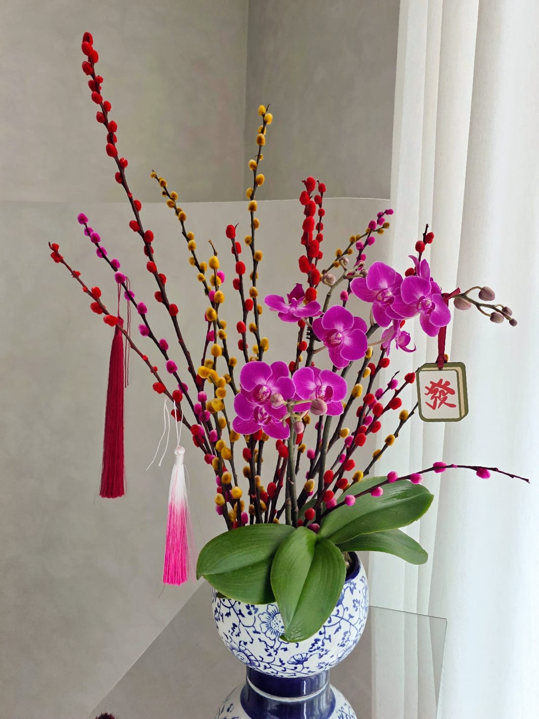 Prosperity willow and orchid arrangement in blue and white porcelain pot