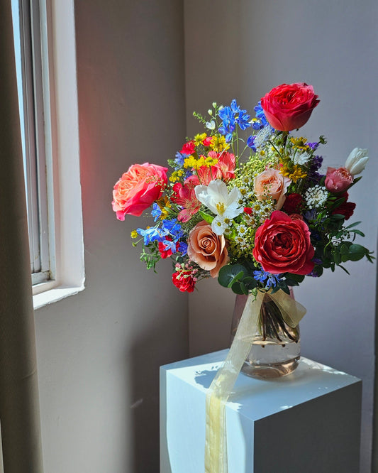 Full view of a vibrant mixed flower bouquet in warm yellows, oranges, and pinks, handcrafted by Flowers by Terra Singapore
