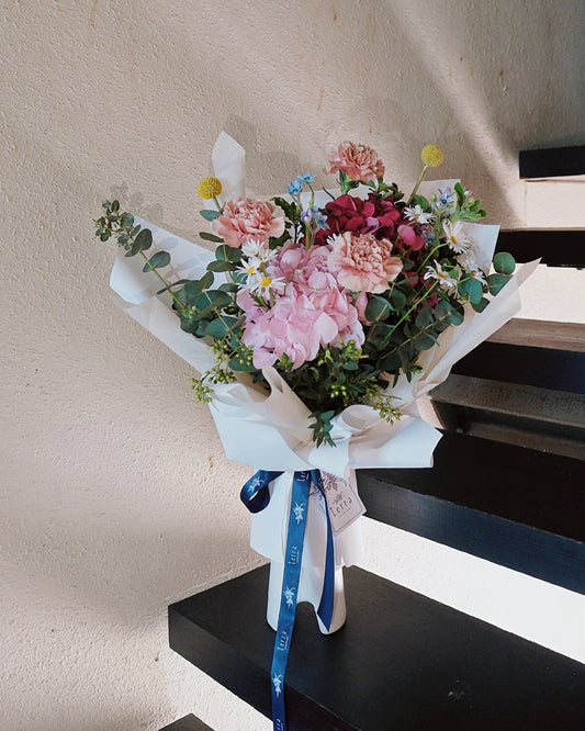 Playful and vibrant Motherâ's Day bouquet with dusty pink Dutch carnations, pink and red hydrangeas, Margarite daisies, and billy buttons designed for the fun-loving mum.