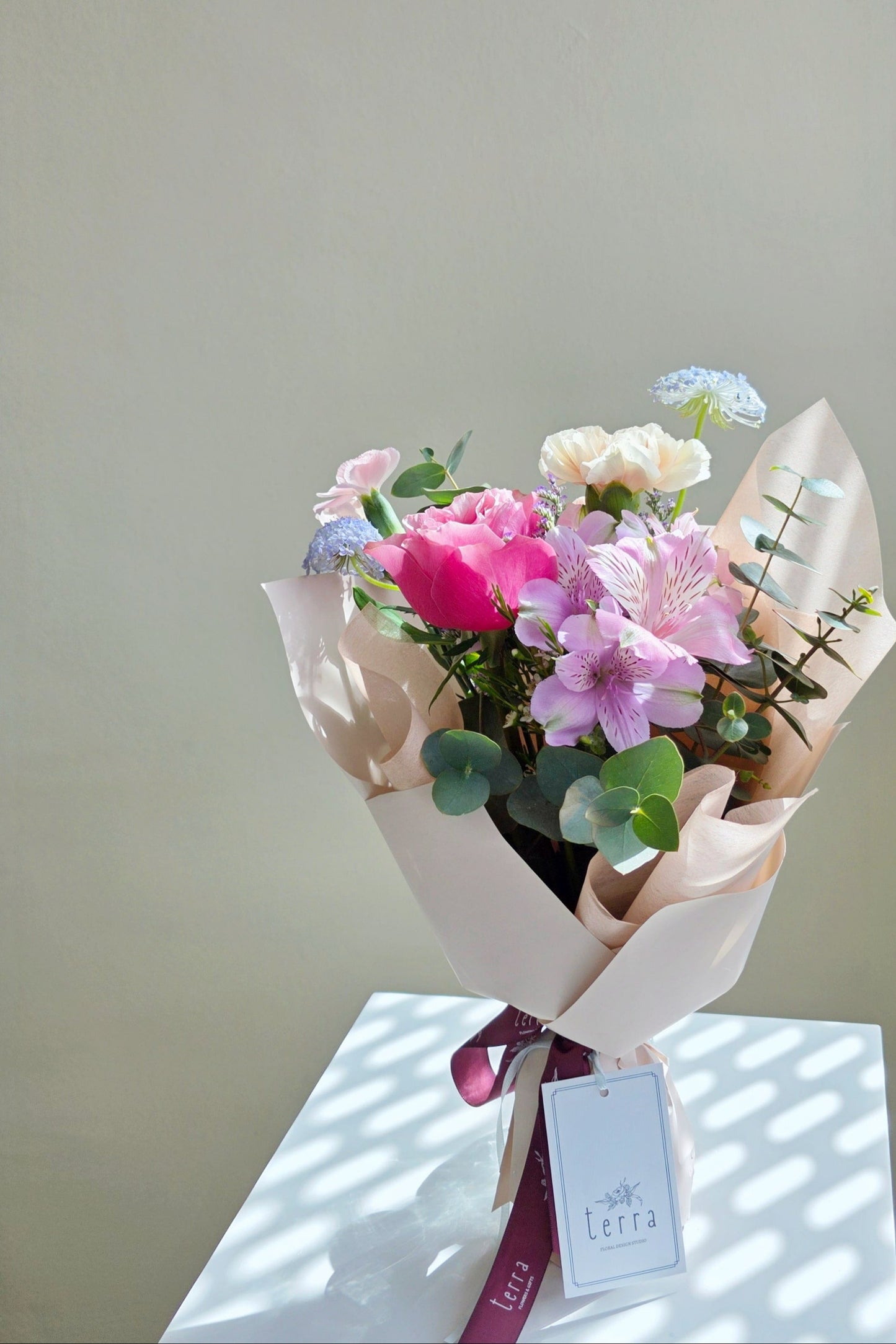 Mother’s Day bouquet with pink garden rose, blush carnations, and blue didiscus – soft, elegant, and full of natural charm.