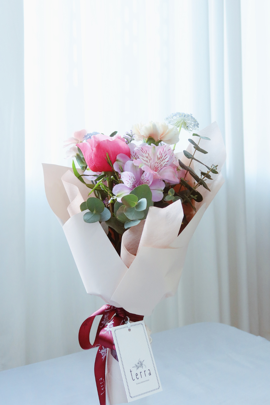 Mother’s Day bouquet with pink garden rose, blush carnations, and blue didiscus – soft, elegant, and full of natural charm.