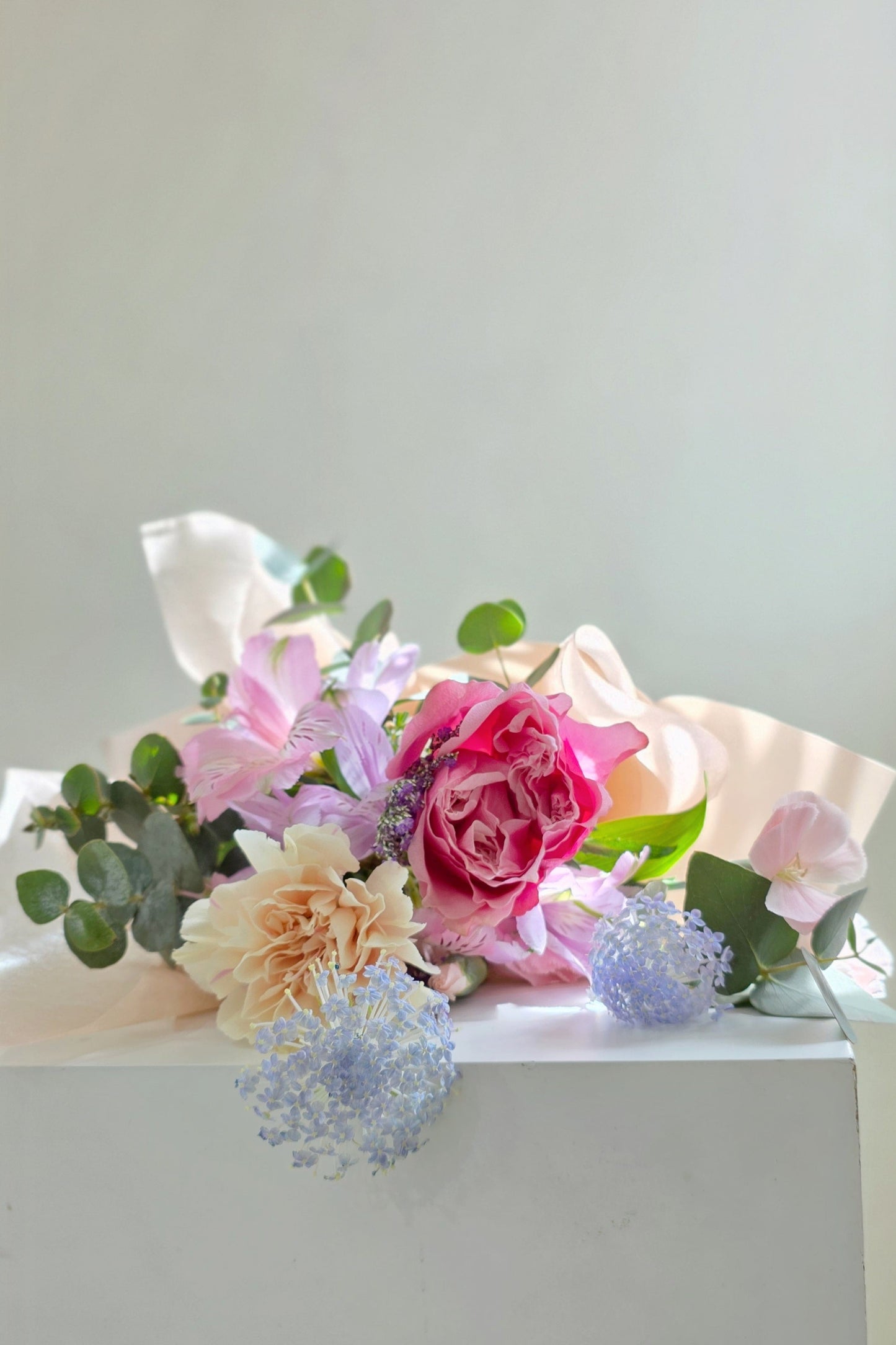 Mother’s Day bouquet with pink garden rose, blush carnations, and blue didiscus – soft, elegant, and full of natural charm.