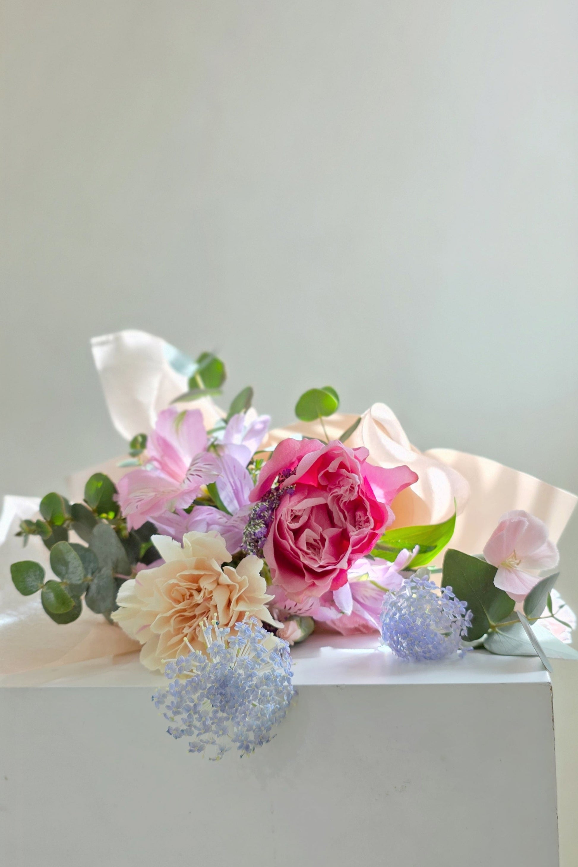 Mother’s Day bouquet with pink garden rose, blush carnations, and blue didiscus – soft, elegant, and full of natural charm.