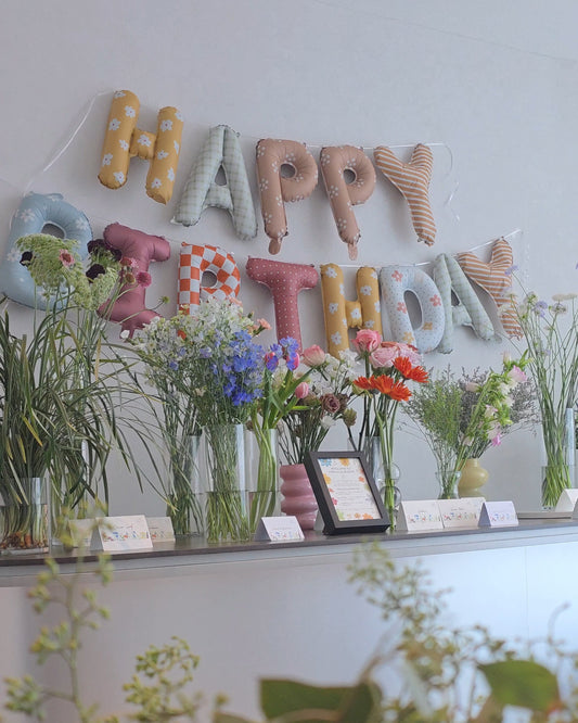 Private birthday flower workshop at Flowers by Terra studio, Singapore — pastel Happy Birthday balloons and fresh seasonal blooms