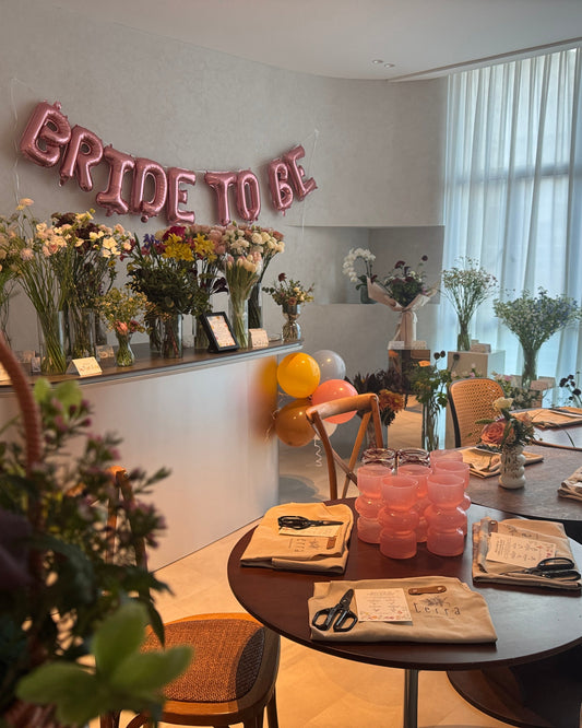Decorated room with 'Bride to Be' balloons, floral arrangements, and tables set for a celebration.