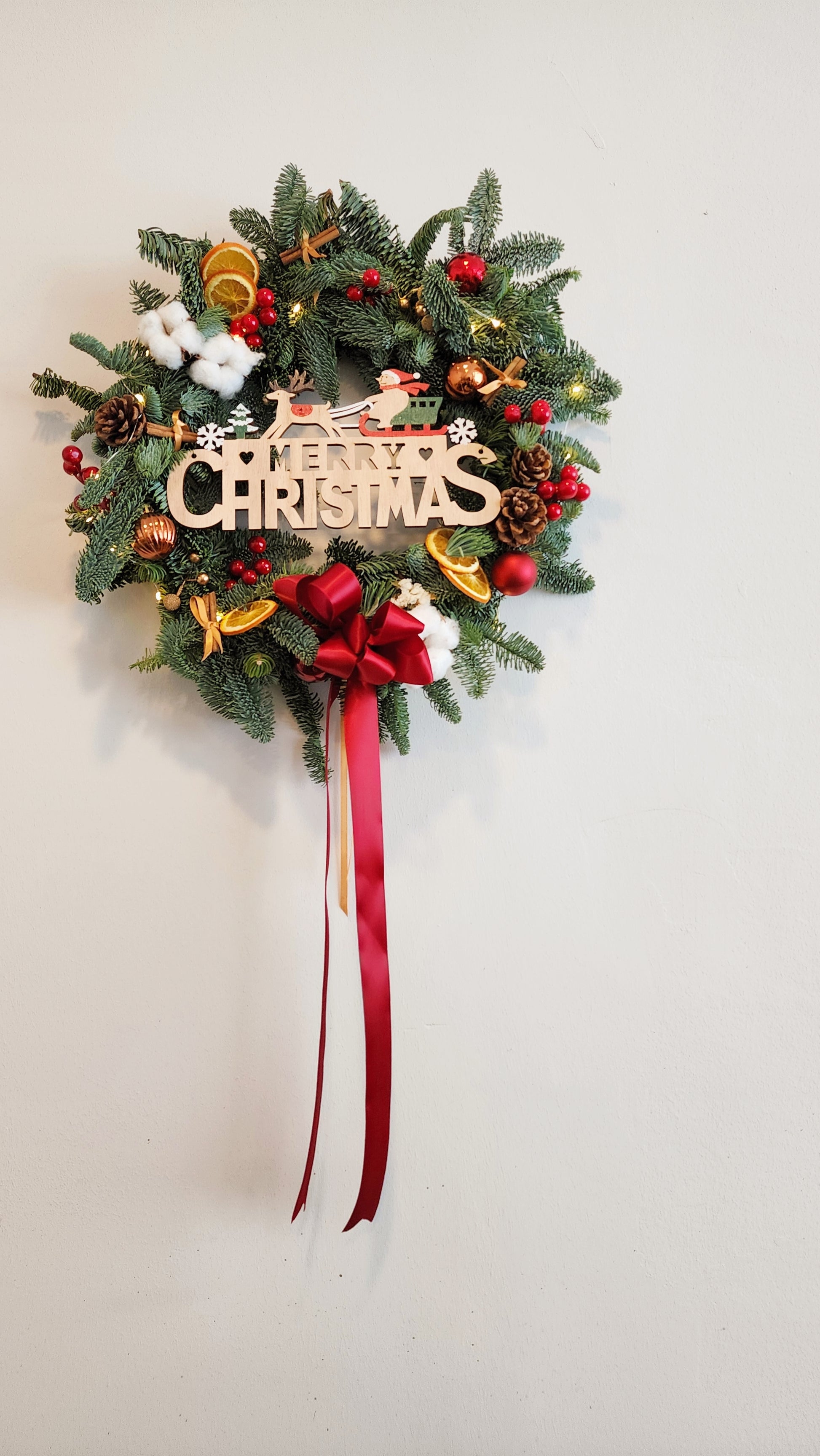 Decorative Christmas wreath with festive decorations on a plain background