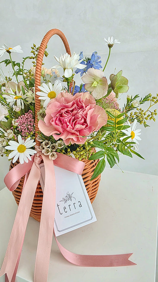 Pastel Mother’s Day floral basket with daisies and pink carnation focal bloom