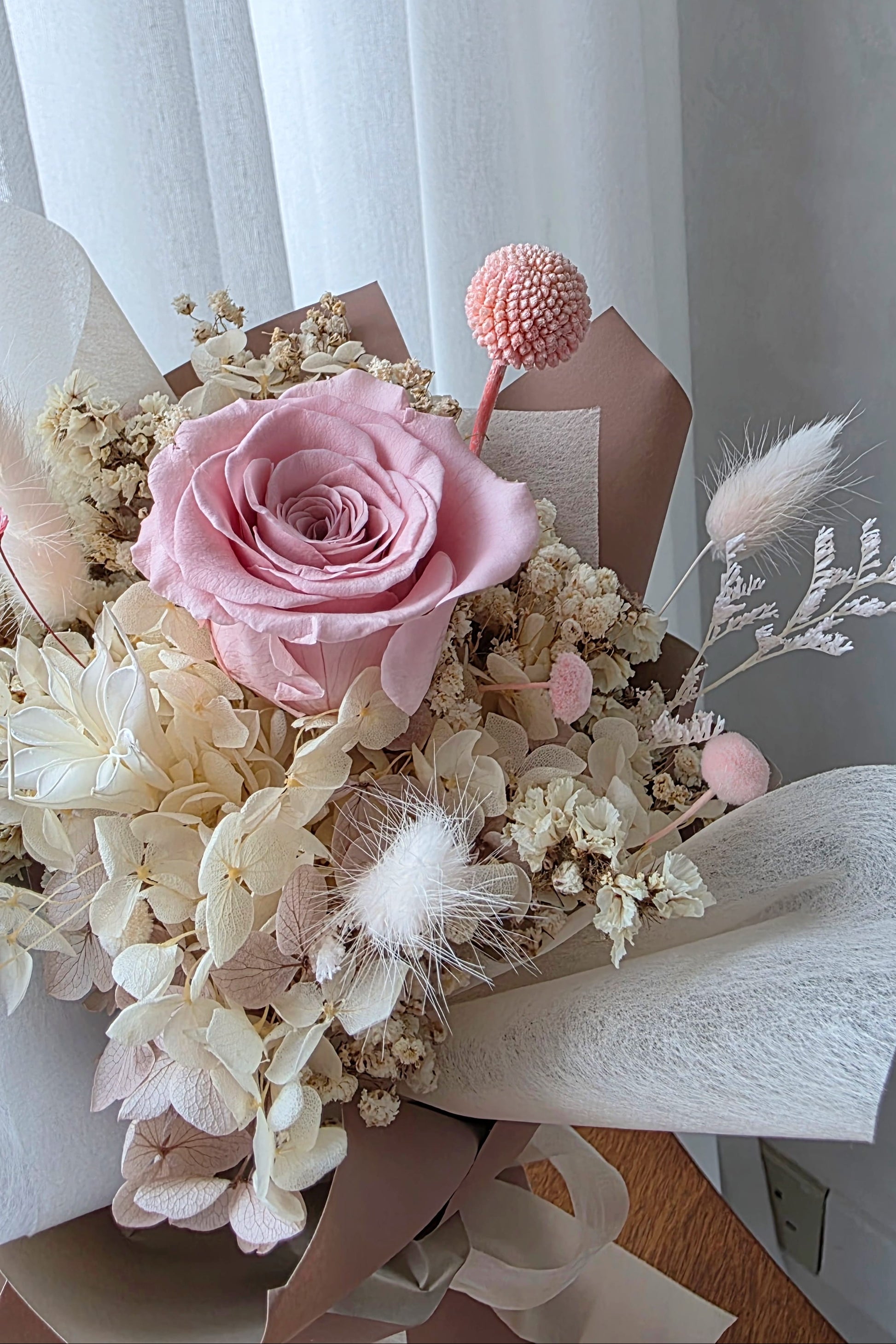 Single blush everlasting rose posy with preserved flowers in neutral wrapping