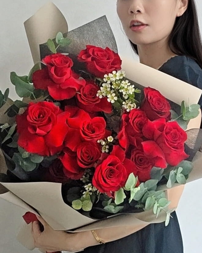 Woman holding a large red rose bouquet for Valentine’s Day