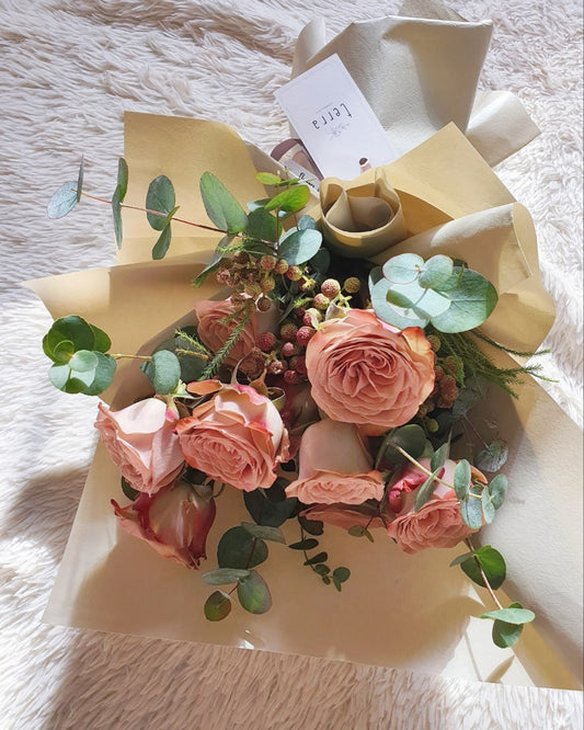 Close-up of dusty mauve menta roses in The Enigmatic Muse bouquet — spiral petal detail with eucalyptus accents, handcrafted by Flowers by Terra Singapore