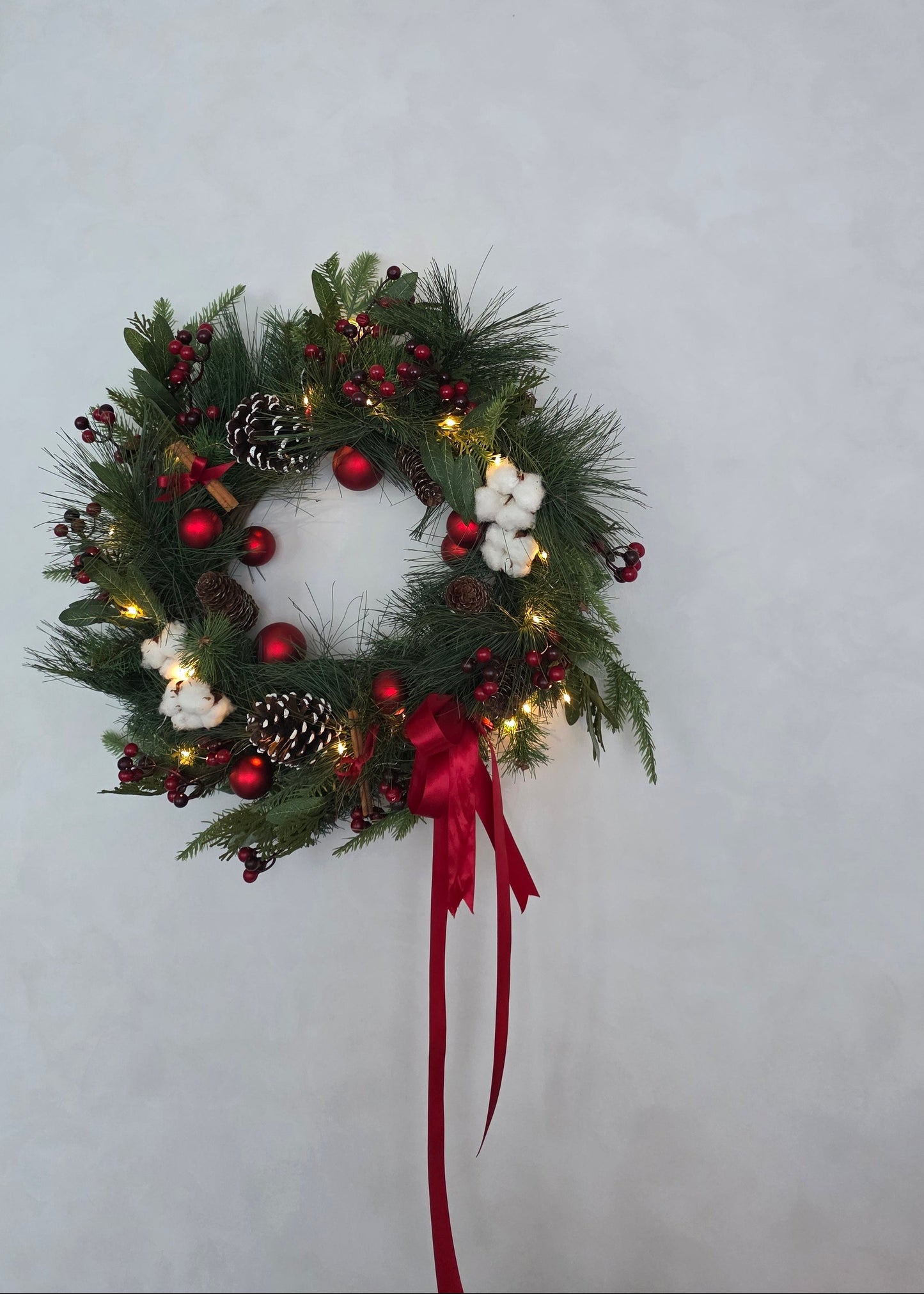 Faux Christmas wreath with red baubles, pinecones, cotton flowers and berries by Flowers by Terra
