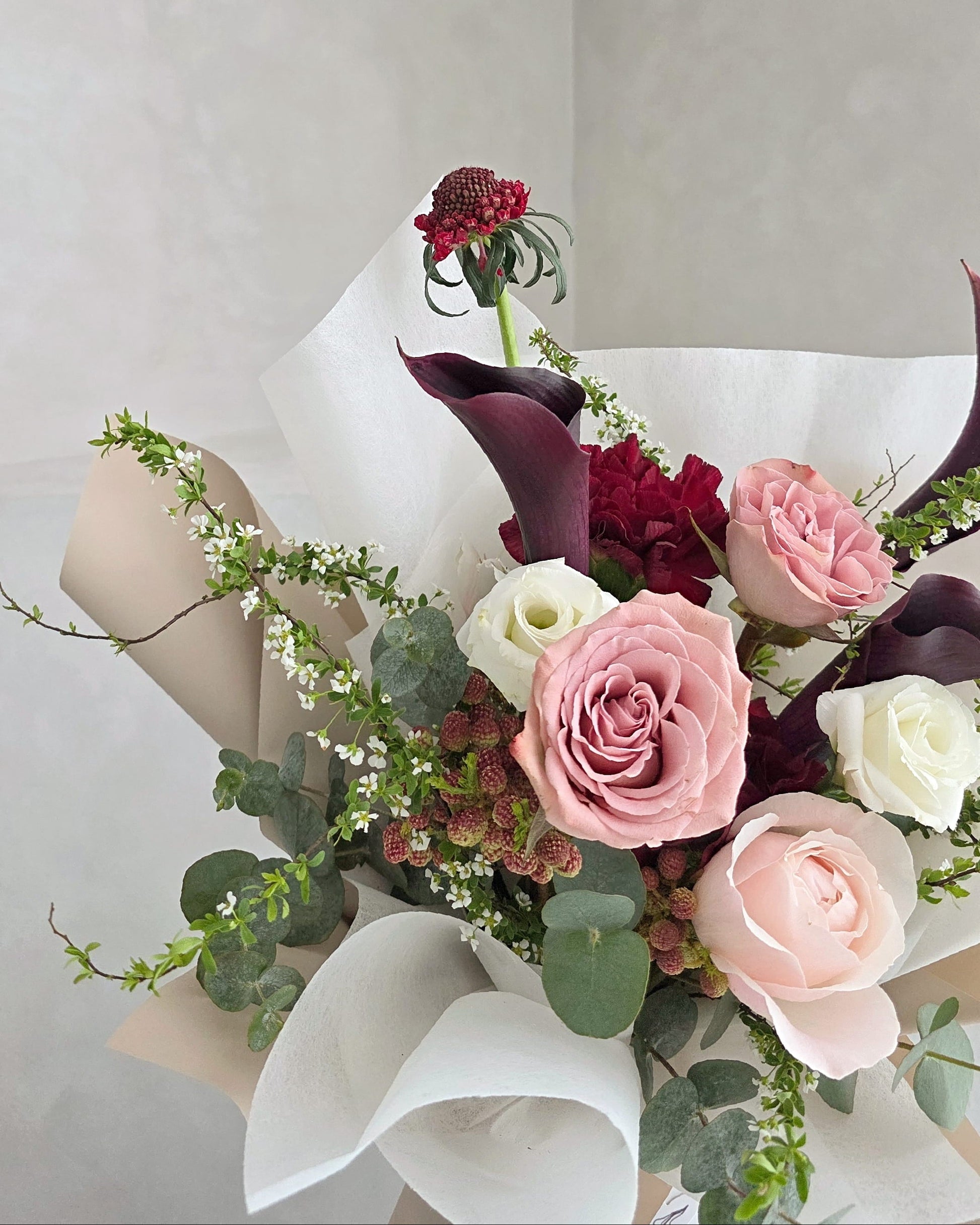 Modern statement bouquet with calla lilies, blush roses and seasonal foliage