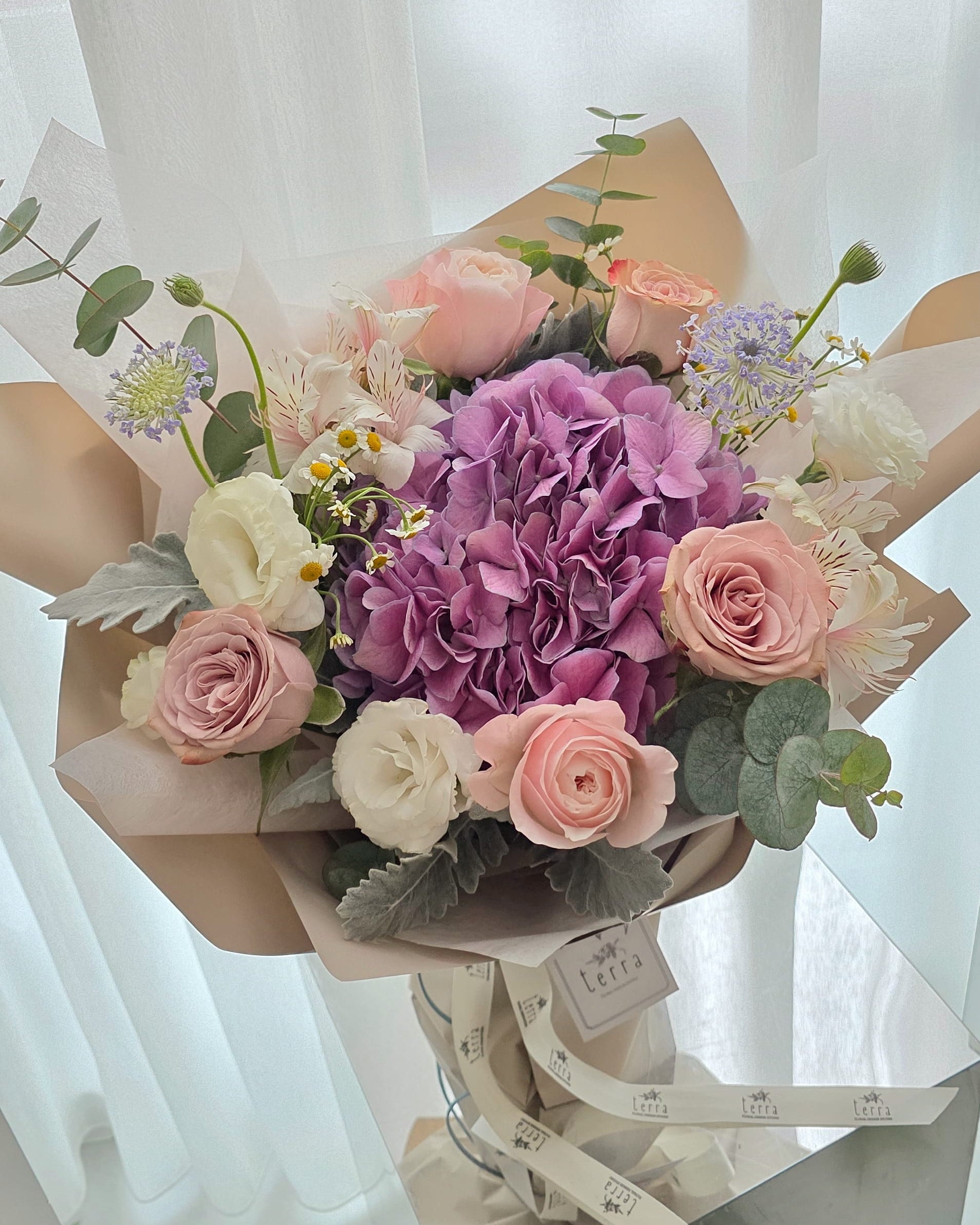 Pastel hydrangea and blush rose bouquet with seasonal flowers in a garden style arrangement