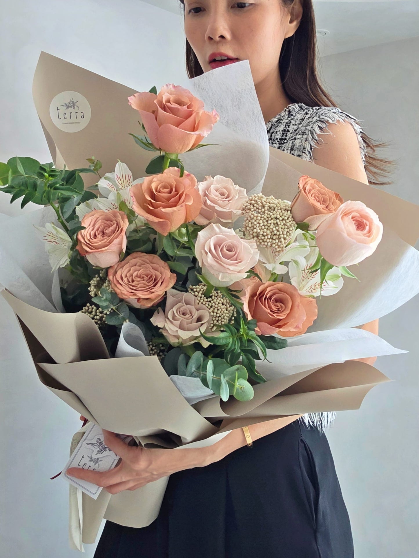 Florist holding Flowers by Terra Antique Rose Bouquet showing full arrangement size — peach, blush and mauve roses, Singapore flower delivery