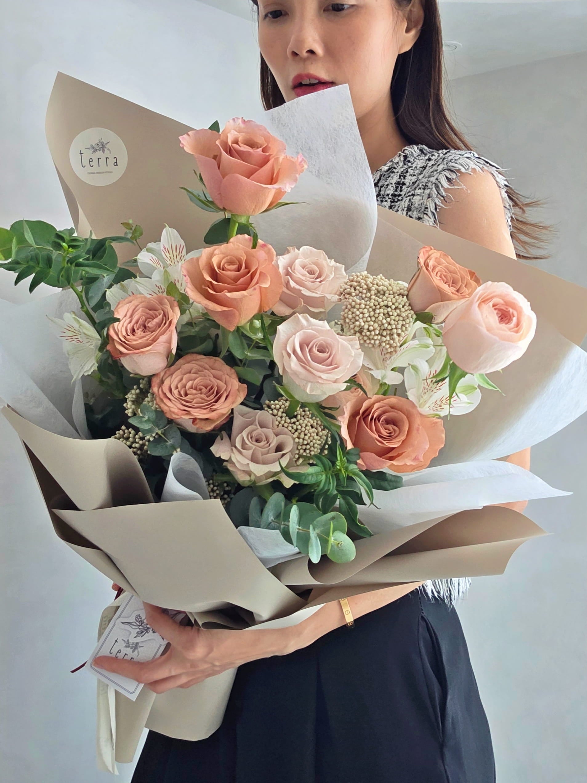 Florist holding Flowers by Terra Antique Rose Bouquet showing full arrangement size — peach, blush and mauve roses, Singapore flower delivery