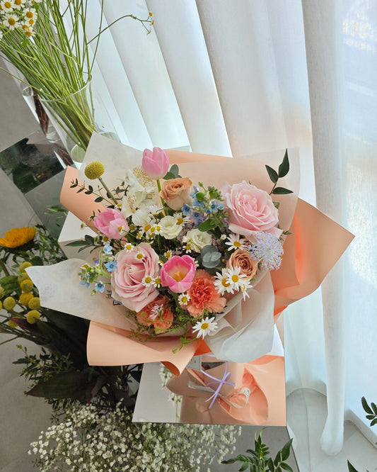 Large Mother's Day bouquet with pink roses, tulips, peach carnations and white daisies in peach and cream paper — Her Garden by Flowers by Terra Singapore 2026