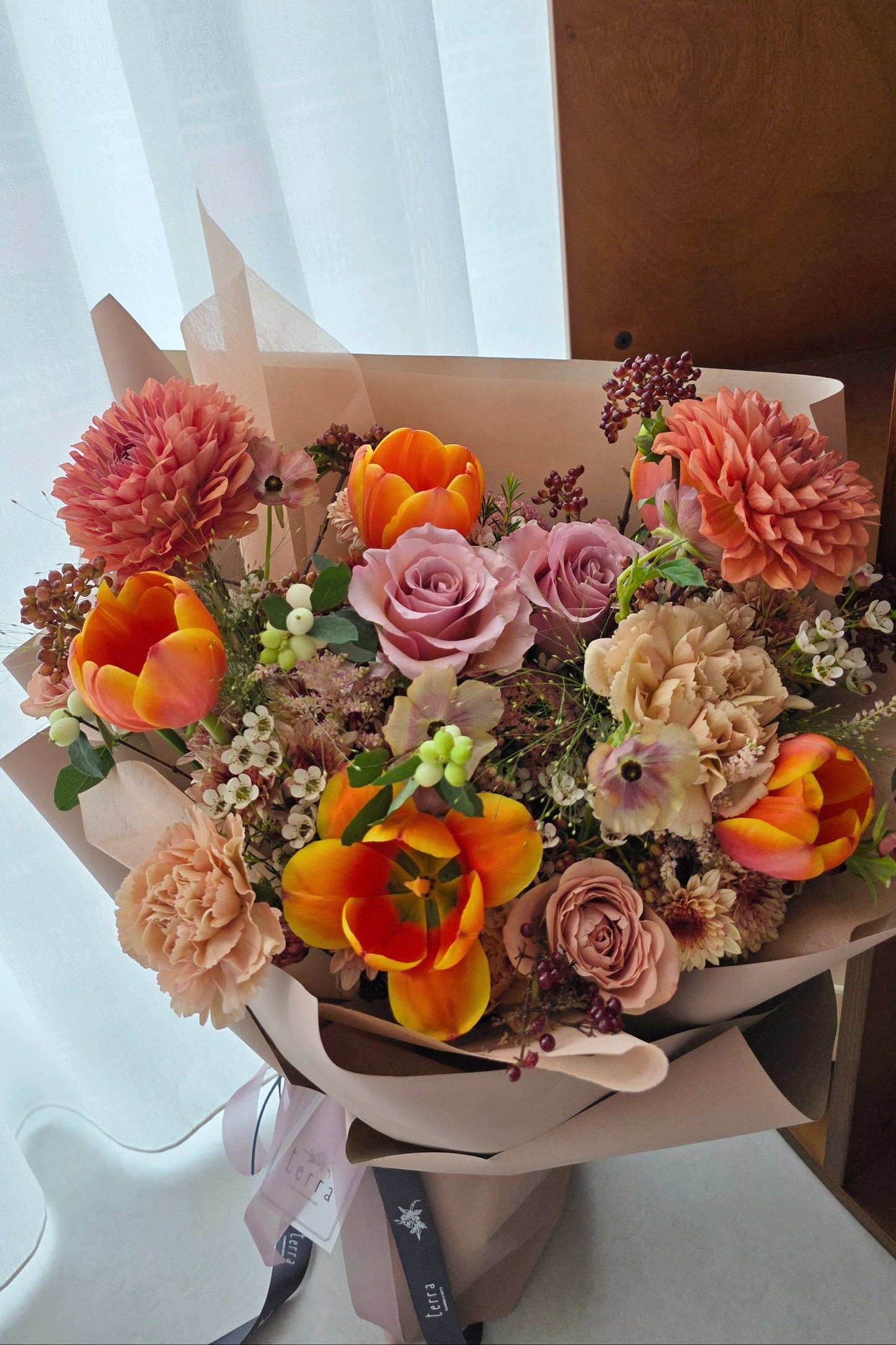 Handcrafted Terra’s Choice designer bouquet in warm earthy colour palette with seasonal flowers, wrapped in soft neutral paper.