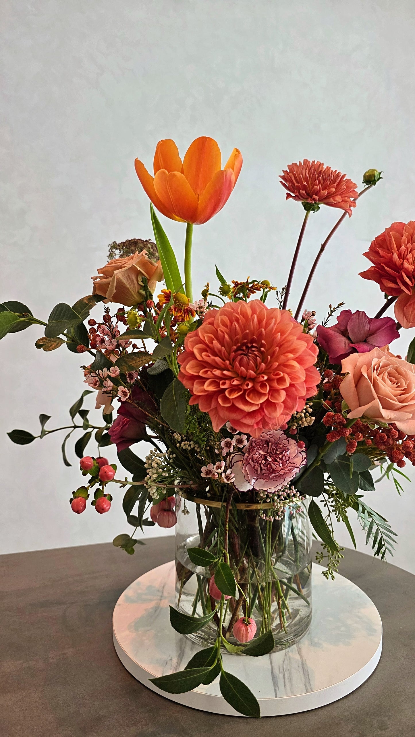 Designer vase arrangement from Terra’s Choice omakase collection featuring coral dahlias, roses, berries and natural greenery.
