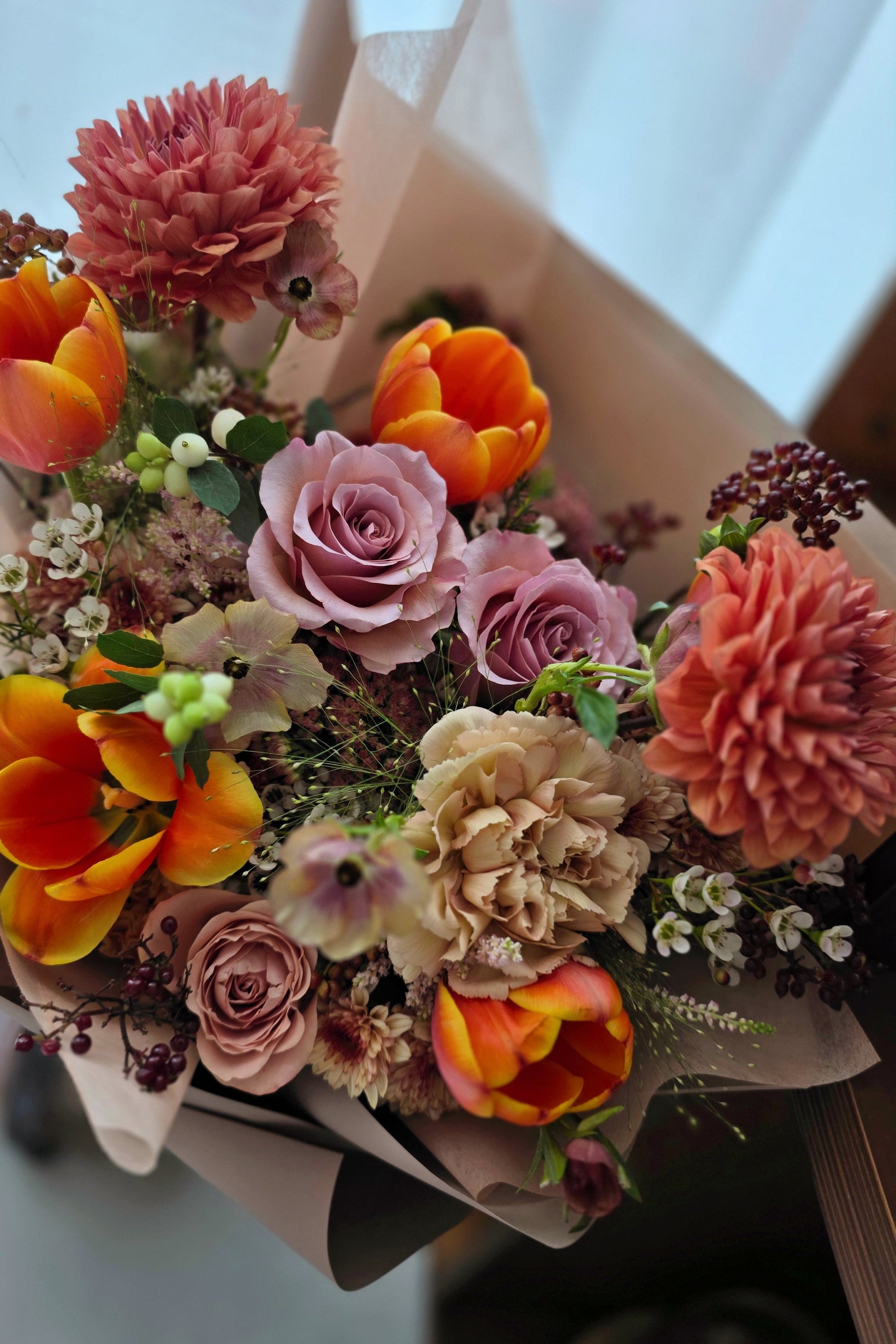 Close-up of Terra’s Choice omakase bouquet highlighting coral dahlias, peach roses, tulips and textured seasonal flowers in warm earthy tones.