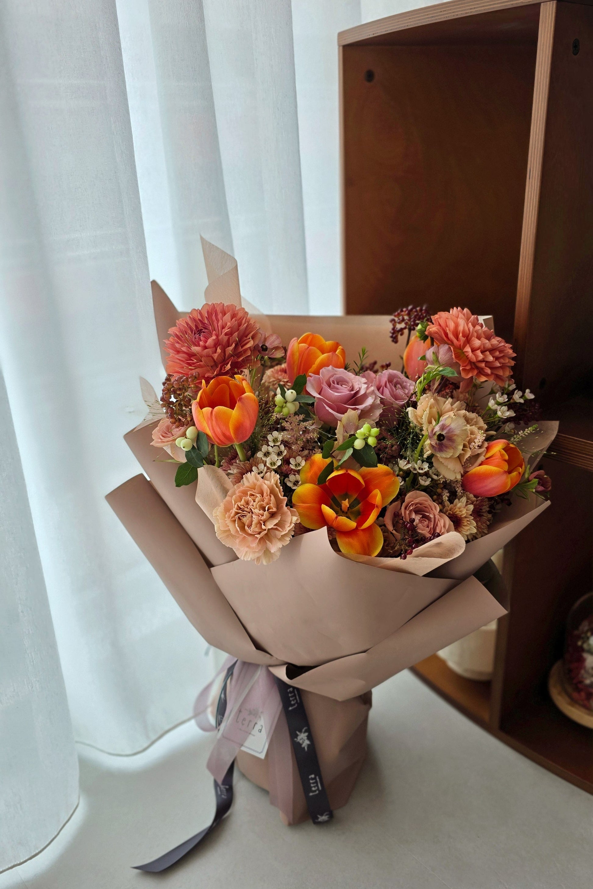 Designer-curated Terra’s Choice omakase bouquet in warm earthy tones featuring coral dahlias, tulips, roses and seasonal foliage by a Singapore florist.