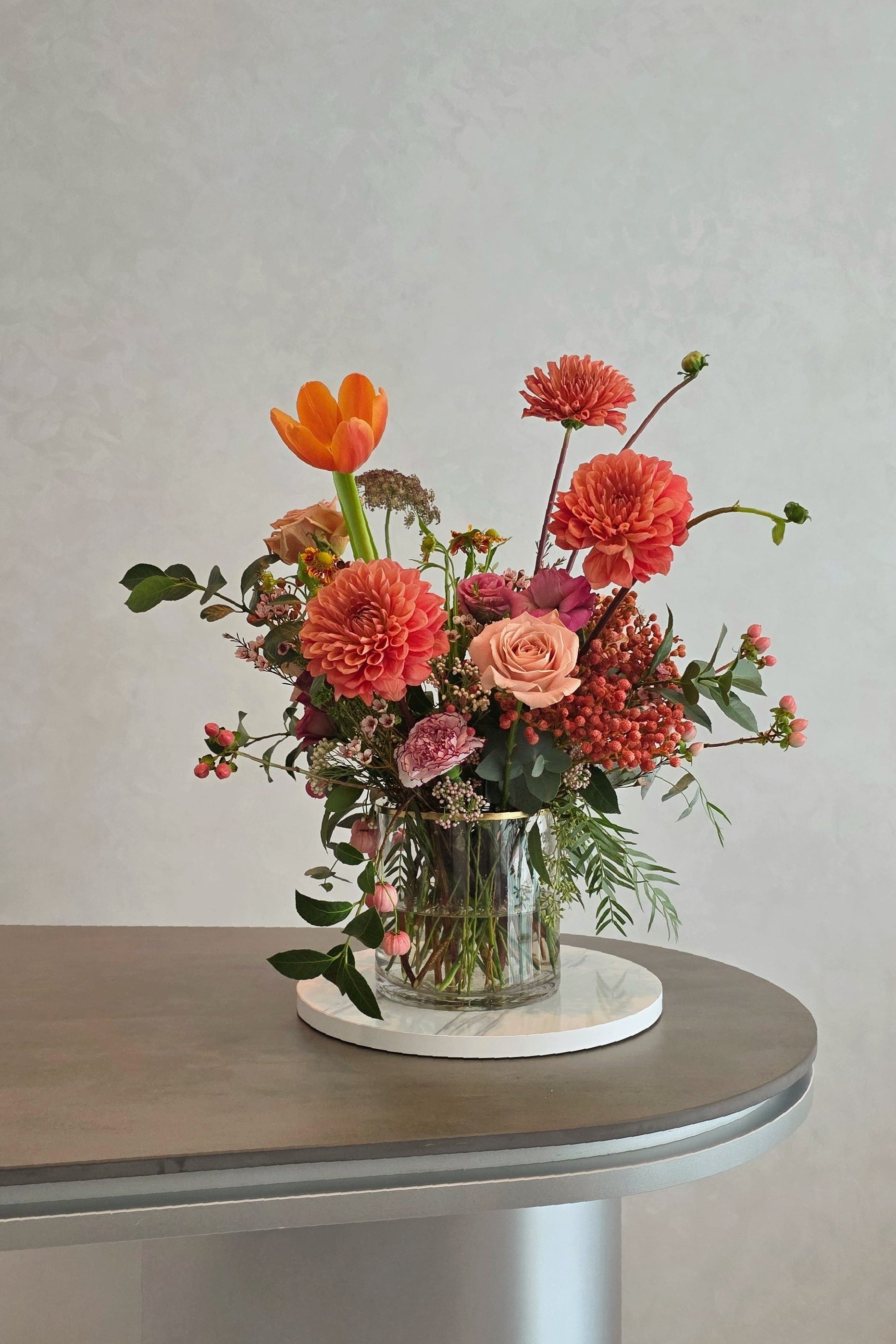 Terra’s Choice omakase floral arrangement in a glass vase with warm coral and earthy tones, designed using seasonal flowers in Singapore.