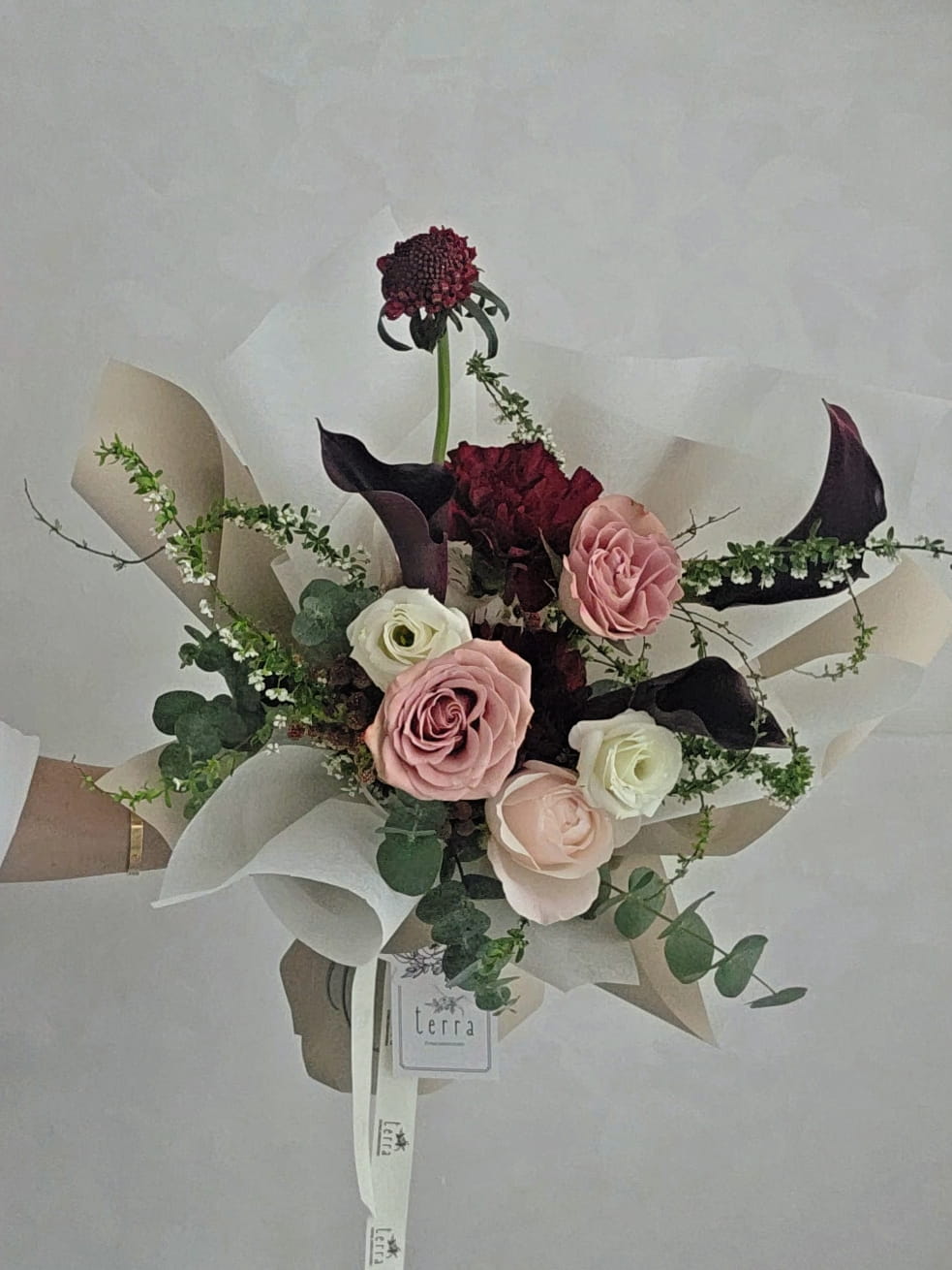 Close-up of calla lilies and garden roses in a contemporary floral arrangement