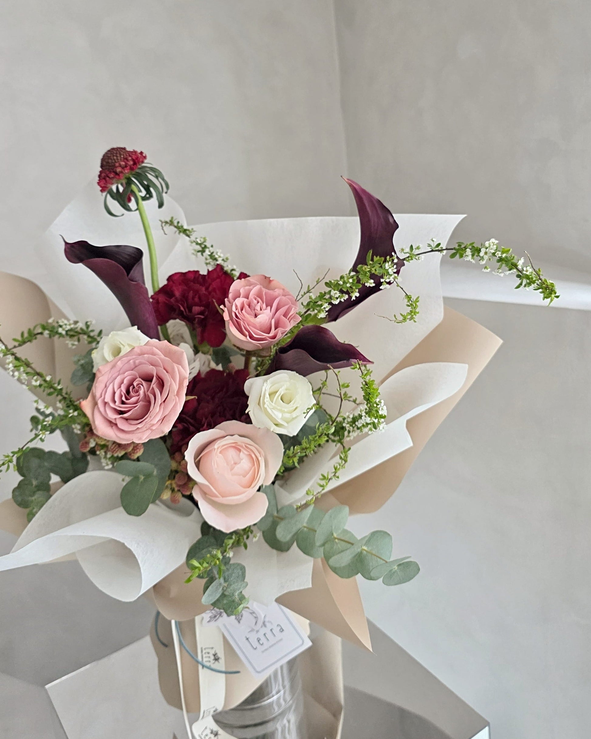 Close-up of calla lilies and garden roses in a contemporary floral arrangement